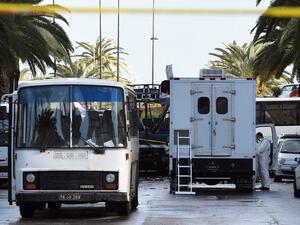 Tunisian police continue to investigate the wreckage of the bombed bus in Tunis, Tunisia. (AFP/Fethi Belaid)