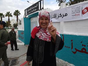 A Tunisian woman voter showcases her ink-stained index finger outside a polling station in Ben Arous near the capital Tunis on May 6, 2018. (AFP/File Photo)