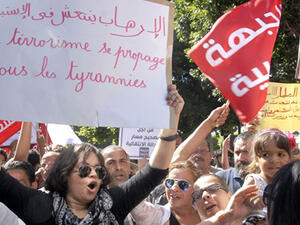 Tunisian protesters hold placards and shout slogans during a protest against a controversial draft law on amnesty for corruption offences in the capital Tunis on Sept. 12, 2015. (AFP)