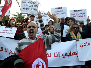 Tunisians shout slogans during a demonstration outside parliament in Tunis on Saturday against allowing Tunisians who joined the ranks of extremist groups to return to their country. (AFP/File)