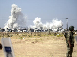 Turkish border guards watch as smoke rises from an airstrike in Syria. (AFP/File)
