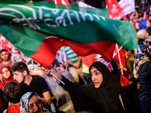 A woman waves flags during a pro-Erdogan rally in Taksim square in Istanbul on July 22, 2016, following the failed military coup attempt of July 15. (AFP/Ozan Kose)