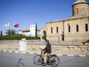 A man bicycles past the Greek Orthodox church of Saint Mamas in the town of Morphou in the self-proclaimed Turkish Republic of Northern Cyprus (TRNC) on November 2, 2016. (AFP/Florian Choblet)