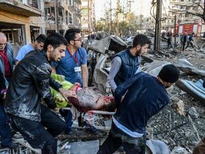 Rescue officials and people carry an injured man at the explosion site on November 4, 2016 after a strong blast in the southeastern Turkish city of Diyarbakir. (AFP/Ilyas Akengin)