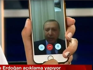 A Turkish TV presenter holds up her iPhone during a FaceTime call with President Recep Tayyip Erdogan as a coup attempt was underway. (Twitter)