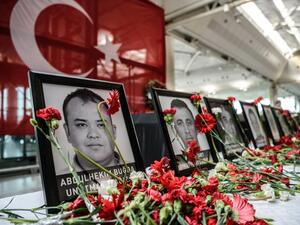 Flowers left by airport employees next to photos of victims killed during the triple suicide bombing and gun attack at Istanbul's Ataturk airport. (AFP/Ozan Kose)