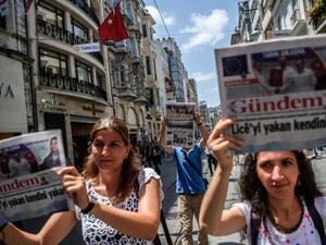 Demonstrators hold copies of pro-Kurdish newspaper Ozgur Gundem as they a protest against the arrest of three press freedom activists on June 25, 2016 in Istanbul (AFP Photo/Ozan Kose)