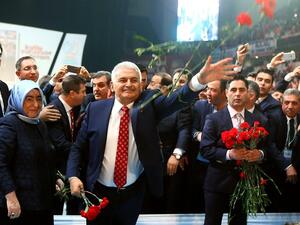 Turkey's Minister of Transport, Maritime and Communication and new chairman candidate for ruling AK Party Binali Yildirim throws red carnations to supporters as he arrives for the second extraordinary congress in Ankara, on May 22, 2016. (AFP/Adem Altan)