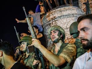 Turkish solders stay with weapons at Taksim square as people protest against the military coup in Istanbul on July 16, 2016. (AFP/Ozan Kose)