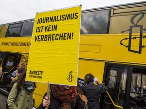 Placard reads "journalism is not a crime" at concert in Berlin on International Press Freedom Day (John Macdougall/AFP)