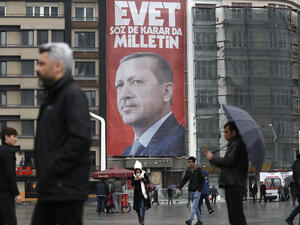 ISTANBUL, TURKEY, 13 MARCH 2017 People walk in front of a picture of Turkish President Recep Tayyip Erdogan. 