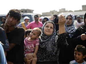 A Syrian refugee woman gestures as she waits for supply near the Turkish border post of Akcakale in the province of Sanliurfa, June 17, 2015. (AFP)