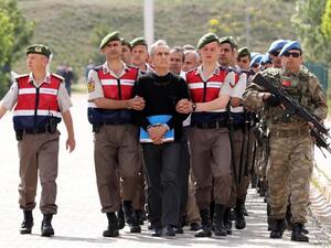 Turkish Gendarmerie escort defendants Akin Ozturk (3L) and others involved in last July’s attempted coup in Turkey as they leave the prison where they are being held, ahead of their trial in Ankara, on May 22, 2017. (Adem Altan/AFP)
