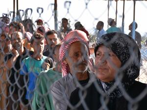 Displaced Syrians queue at a Kurdish controlled checkpoint between the rebel-held town of Azaz in northern Syria and the city of Afrin, along Syria's northern border with Turkey, as they attempt to cross on June 9, 2017. (George Ourfalian/AFP)