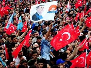 People wave Turkish flags, and one bearing the image of President Recep Tayyip Erdogan. (AFP/ File)