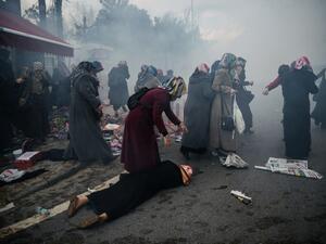 A woman helps a fallen friend as riot police launch tear gas at peaceful protesters outside Zaman in Istanbul. (AFP/Ozan Kose)