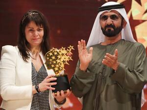 Canadian teacher Maggie MacDonnell (L) receives the Global Teacher Prize from Sheikh Mohammed bin Rashid al-Maktoum, vice-president and Prime Minister of the UAE and Ruler of Dubai, during a ceremony in Dubai on March 19, 2017. (AFP/Karim Sahib)