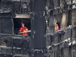 Members of the emergency services work on the middle floors of the charred remnains of the Grenfell Tower block in Kensington, west London, on June 17, 2017, follwing the June 14 fire at the residential building. (Tolga Akmen/AFP)