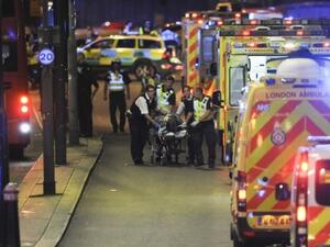 Police officers and members of the emergency services attend to a person injured in a terror attack on London Bridge in central London on June 3, 2017. (AFP/ Daniel Sorabji)