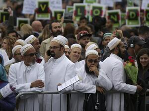 Members of the Dawoodi Bohra Muslim community join others as they bow their heads during a vigil at Potters Fields Park in London on June 5, 2017 to commemorate the victims of the terror attack on London Bridge and at Borough Market that killed seven people on June 3. (Daniel Leal-Olivas/AFP)