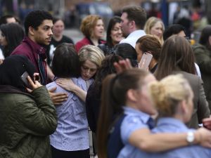 Retail staff hug each other after being evacuated from the Arndale Centre shopping mall in Manchester, northwest England on May 23, 2017 following a security alert the day after a deadly terror attack at the Manchester Arena. (AFP/Ben Stansall)