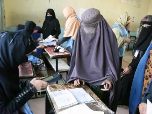 An Afghan Independent Election Commission (IEC) official scans a voter with a biometric device at a polling centre for the country's legislative election in Kandahar province on October 27,2018. (JAWED TANVEER / AFP)