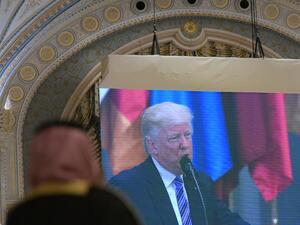 A man watches an image of US President Donald Trump as he speaks during the Arabic Islamic American Summit at the King Abdulaziz Conference Center in Riyadh on May 21, 2017.  (MANDEL NGAN/AFP)