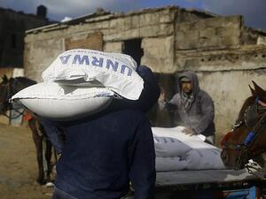 Palestinian loads a horse-pulled cart with food donations outside the United Nations food distribution center in Gaza City on January 15, 2018 (AFP PHOTO / Mohammad Abed)