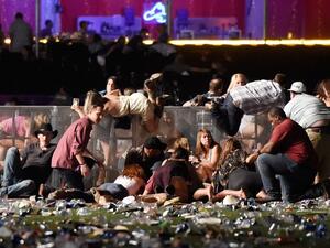 People scramble for shelter at the Route 91 Harvest country music festival after apparent gun fire was heard on October 1, 2017 in Las Vegas, Nevada (David Becker/Getty Images North America/AFP)