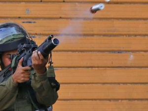 An Israeli soldier fires a tear gas canister during clashes with Palestinian protesters in the center of the occupied West Bank city of Hebron on July 13, 2018. (AFP photo)