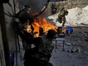 Syrian rebels of the Halab al-Shabah battalion under Al-Tawhid brigade take position during clashes with regime forces in Al-Amariya district of the northern city of Aleppo. (AFP/File)

