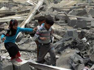 Yemeni children walk through rubble after an airstrike in the Houthi-held Sanaa, capital of Yemen. (AFP/Mohammed Huwais)