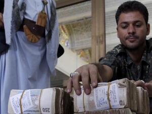 A member of the Houthi militias arranges money donated by Houthi supporters. (AFP/ File Photo)