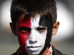A Yemeni child, with his face painted in the colours of his national flag, looks on during an anti-US protest staged by supporters of the Huthi rebels in Sanaa on May 20, 2017. (Mohammed Huwais/AFP)