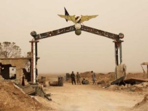 مسلحون عند مدخل المطار العسكري أبو ضهور في إدلب
