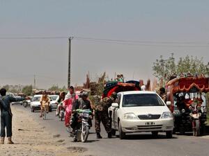 Afghan policemen search commuters at a checkpoint in Helmand province on August 9, 2016. (AFP/Noor Mohammed)