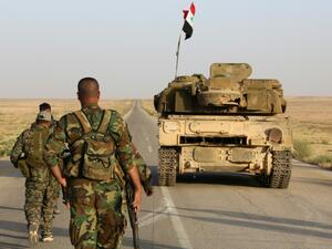 Syrian soldier walk behind a military vehicle (AFP/File Photo)	