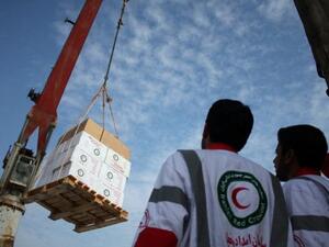 Humanitarian workers from the Iranian Red Crescent loading medical aid. (AFP/File)