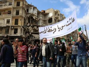 Syrian civilians and activists wave pre-Baath Syrian flags, now used by the Syrian opposition, during an anti-regime demonstration in the rebel-controlled side of Aleppo, on March 4, 2016. (AFP/Karam al-Masri)