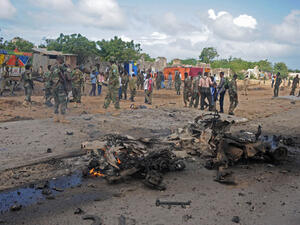 Soldiers patrol around the wreckage of a suicide car bomber that smashed into a pickup truck carrying security officers in Mogadishu. (AFP/File)
