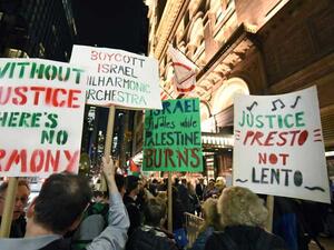 حمل المحتجون لافتات كتبوا عليها عبارات رافضة لوجود الأوركسترا  
