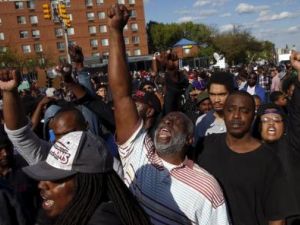 متظاهرون يقفون أمام خط شرطة في بالتيمور بعد يوم من اعمال النهب واشعال الحرائق احتجاجا على وفاة فريدي جراي يوم الثلاثاء
