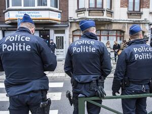 Three police officers stand guard at the Meiser neighborhood in Schaarbeek in Brussels on March 25, 2016 during an operation searching for suspects of March 22 bombings in Brussels. (AFP/Laurie Dieffembacq)