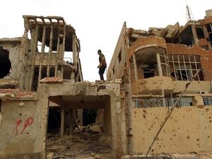 A Libyan man stands atop a destroyed building on February 29, 2016 in Benghazi after the area was retaken by Libya's internationally recognized government. (AFP/Abdullah Doma)