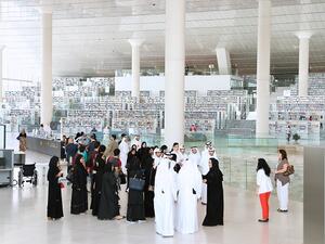 مجموعة من الطلاب يتحدثون مع موظفي مكتبة قطر الوطنية أثناء قيامهم بجولة في مرافق المبنى الجديد