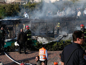 Israeli security forces respond to the burning remains of the bus bombed by a Hamas operative in April. (AFP/File)