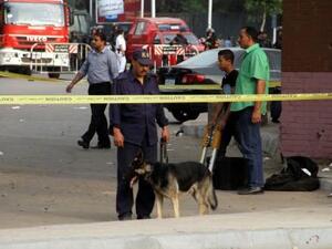 رجل أمن ومعه كلب يستخدم للكشف عن المفرقعات في مسرح انفجار قنبلة بالقرب من جامعة القاهرة
