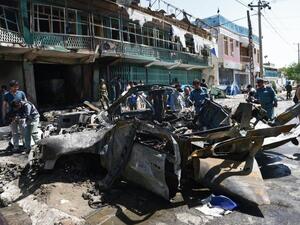 Afghan police walk around a destroyed U.S. military vehicle at the site of a suicide attack in Kabul on May 16, 2013. (AFP/Massoud Hosseini)