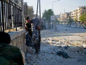 A man carrying a wounded friend after airstrikes in Idlib. (AFP/File)