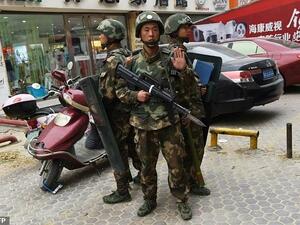 Paramilitary police stand guard outside a mall in Hotan, in China's western Xinjiang region. (AFP/File) 